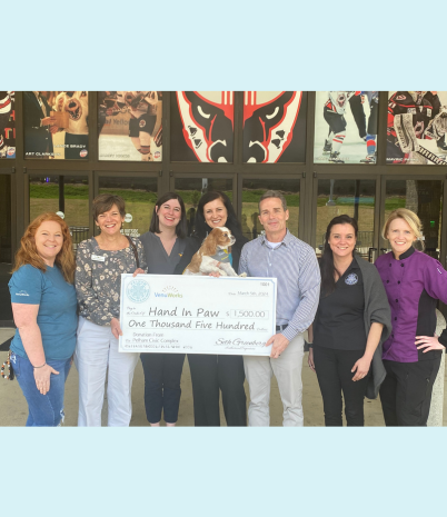Members of the Pelham Civic Complex & Ice Arena present a check to Hand In Paw.