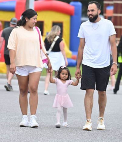 Mom, Dad, and daughter walking in front of colorful inflatables