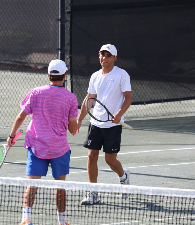 Two jr tennis players shaking hands on the court